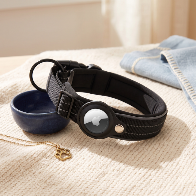 Black AirTag dog collar on cream knit fabric with navy bowl
