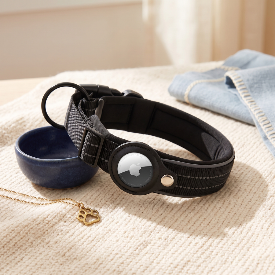 Black AirTag dog collar on cream knit fabric with navy bowl